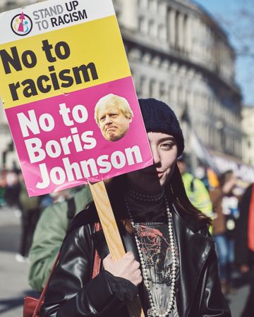 London, England, United Kingdom - March 19 2022: Woman with “no to racism” sign