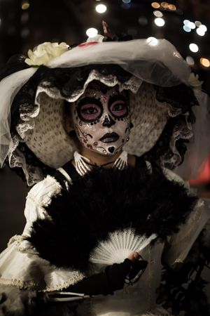 Woman wearing hat with sugar skull face paint