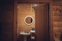 Bathroom in wooden house with opened door