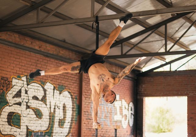 man athlete doing a one hand handstand, calisthenics