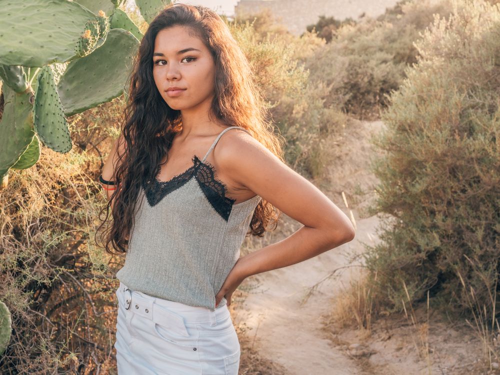 Playful trendy young woman in deserted countryside