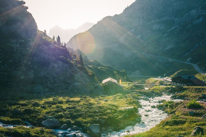 Shallow river flowing along rocky shore in bright day
