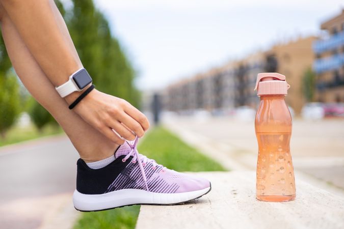 Female athlete tying running shoe laces for running workout