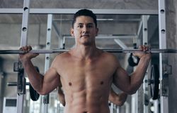 Male bodybuilding with weight on back in rack