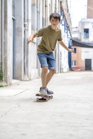 Front view of serious skater boy riding on the street