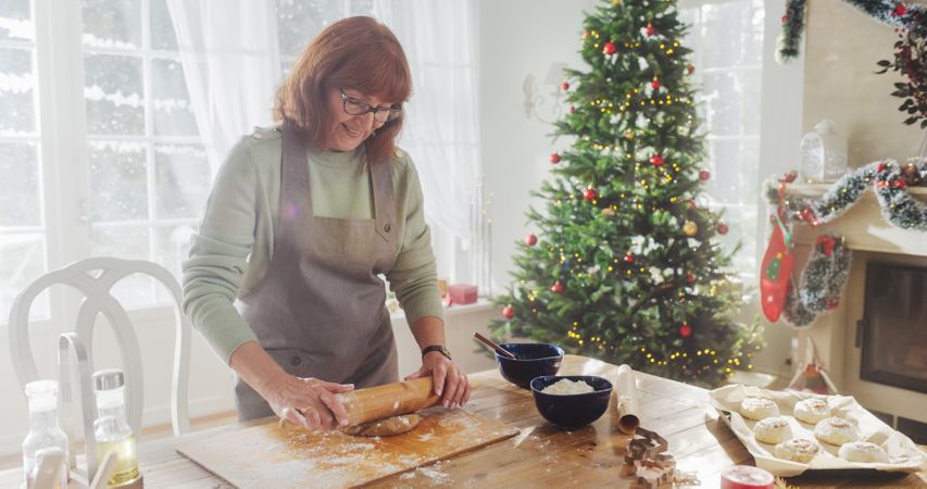 Portrait of Mature Female Making Gingerbread Cookies for Christmas at Home.