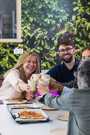 Diverse colleagues having lunch together in kitchen of office