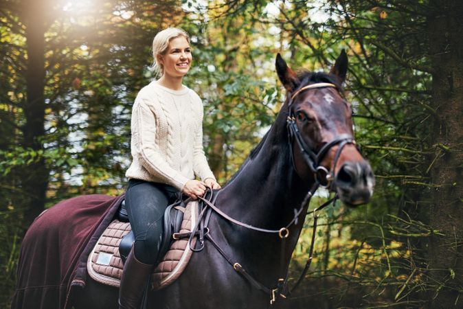 Young woman in happy mood as she takes a relaxing ride with her horse companion