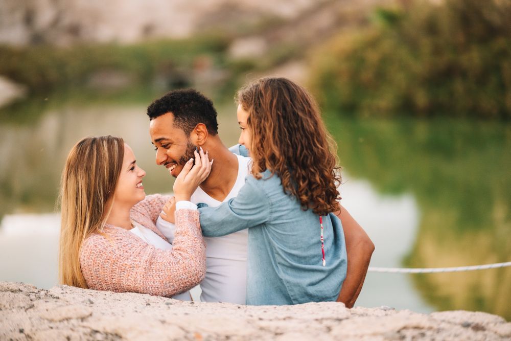 Cheerful multiethnic family cuddling on nature