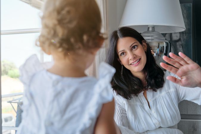 Loving mother playing with daughter at home