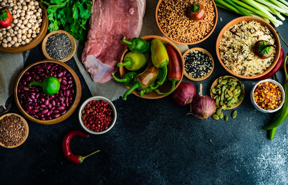 Dark kitchen counter with grains and aromatics for pork cutlet dinner