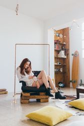 Woman sitting in chair and texting in trendy loft