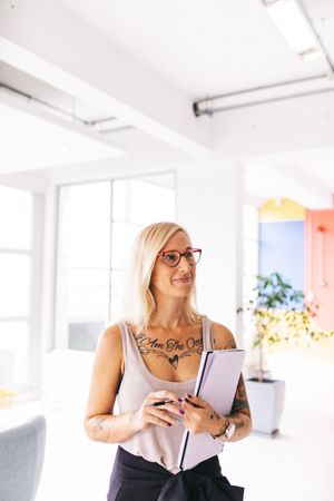 Woman holding a notepad in a bright modern office