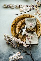 Minimalistic table setting with apricot blossom with rustic brown plates