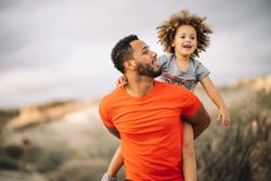 Black father holding child in arms