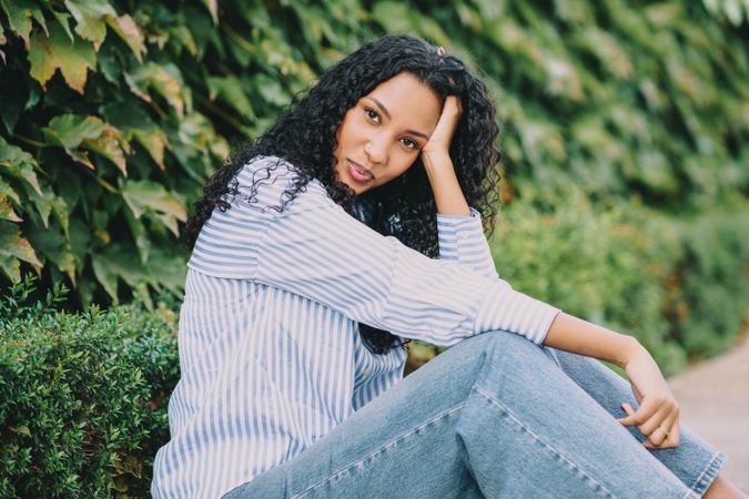A Casual Portrait Featuring a Young Woman with Beautiful Curly Hair Surrounded by Nature