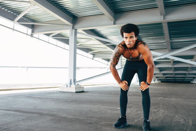 Athletic Black male with tattoos resting after workout