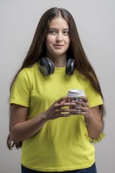 Coffee break: young woman in casual style with takeaway cup, a to-go beverage, enjoying student break.