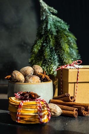 Close up of Christmassy table with dried fruit, strings, cinnamon and holly