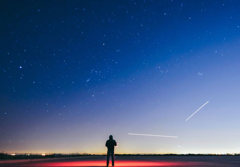 Silhouette of man looking at starry sky