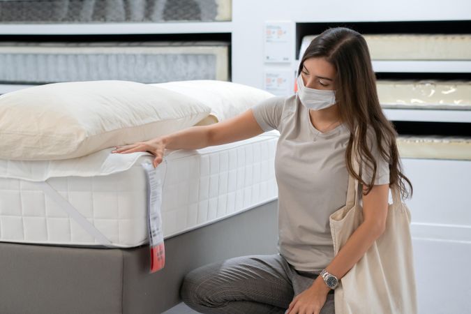 Woman in mattress store wearing surgical mask