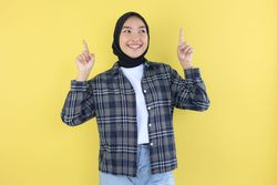 Happy Excited Asian Girl with Hijab Pointing Two Finger Up at Copy Space