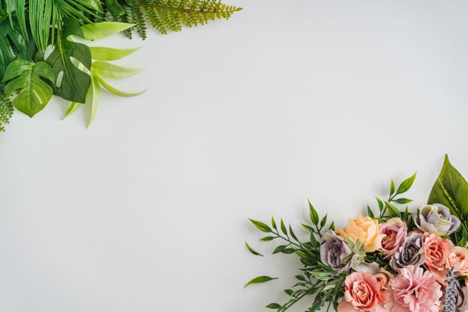 Summer tropical  leaves and spring flowers on corners of light background