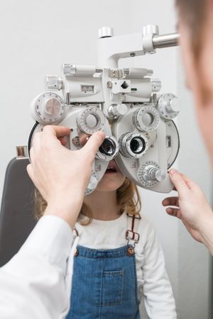 Optician testing a girl's eyes