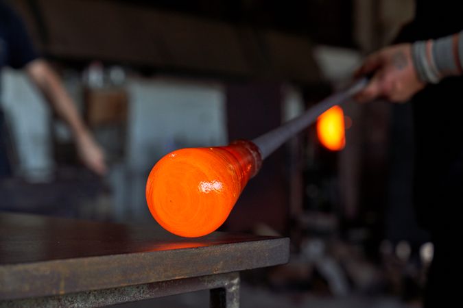 Crop worker forming vase in dark building
