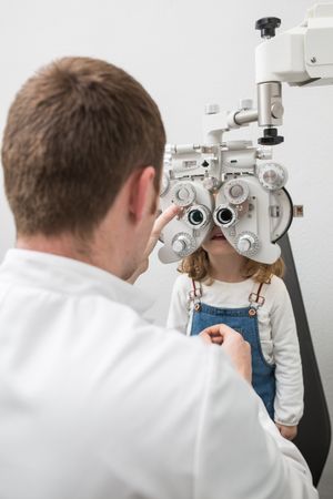 Optician testing a girl's eyes