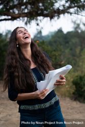 Female director laughing while holding script 0VNQ30