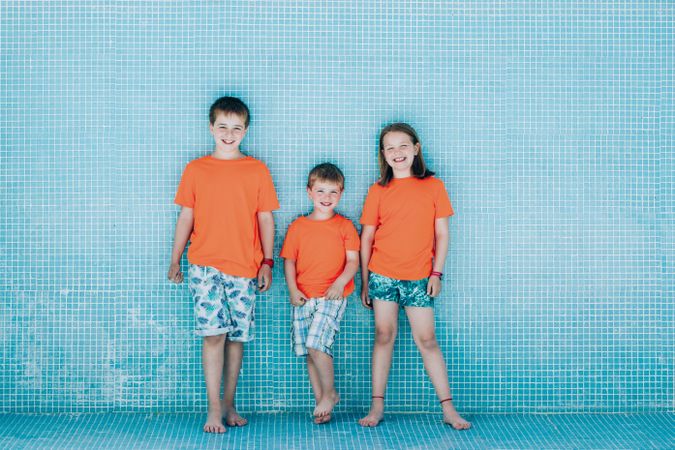 Children standing in empty pool and looking at camera