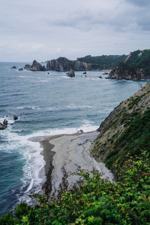 Rocky peaks surrounded by foamy water in windy day