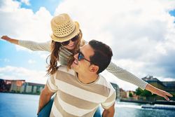 Woman with outstretched arms on boyfriend’s back