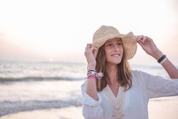 Charming woman in light white dress on wavy beach