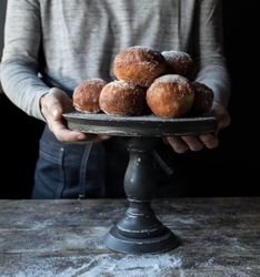 Person near baked cakes on stand on table