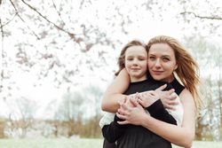 Mother and daughter embracing in park