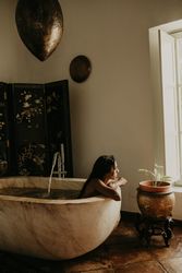 Melancholic Woman sitting and washing in bath