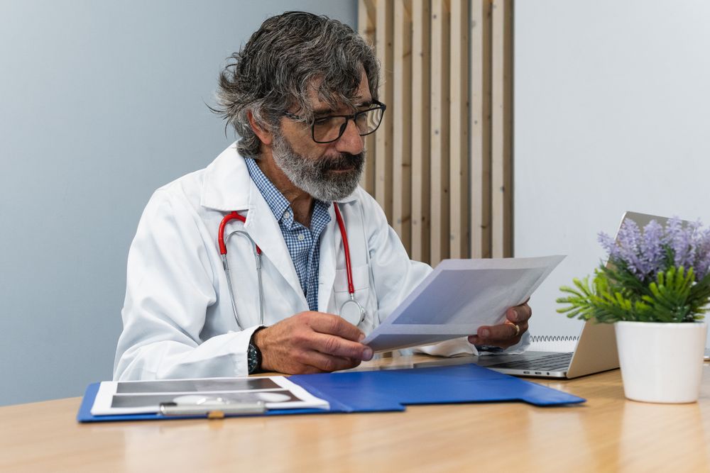 Mature doctor examining x ray in hospital