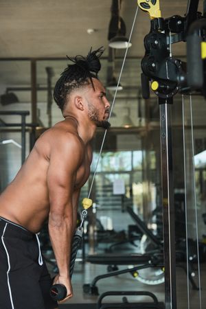 Black guy using exercise machine in gym