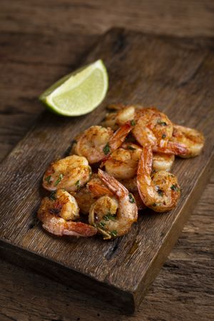 Delicious grilled prawns on wooden background.