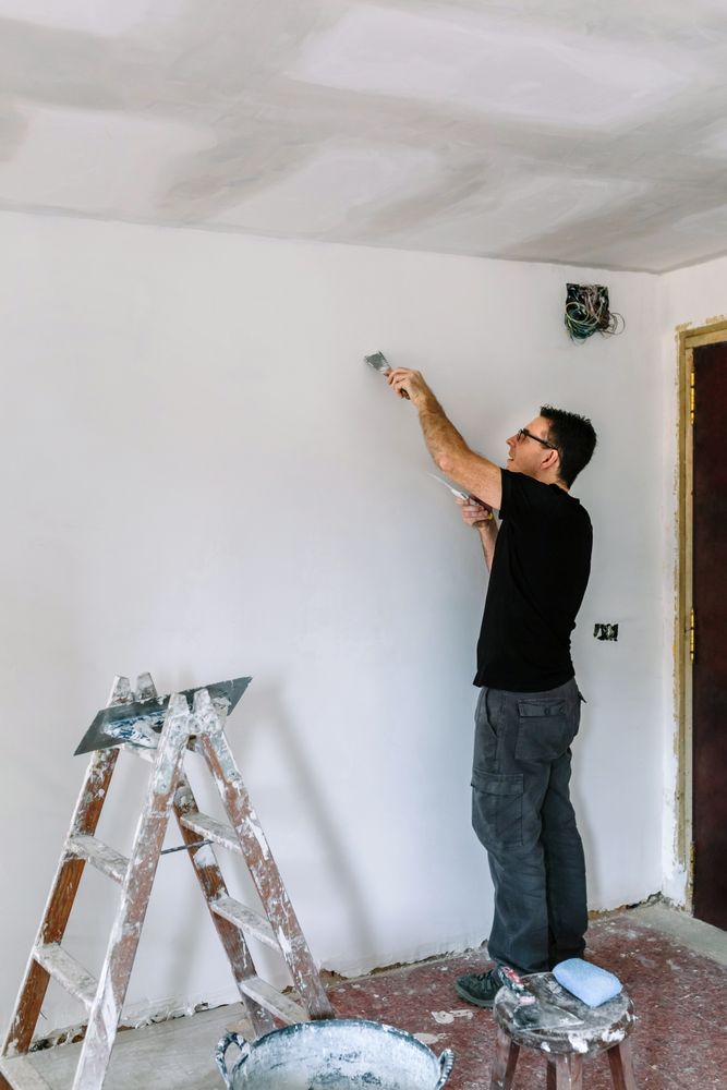 Bricklayer repairing the wall with a spatula
