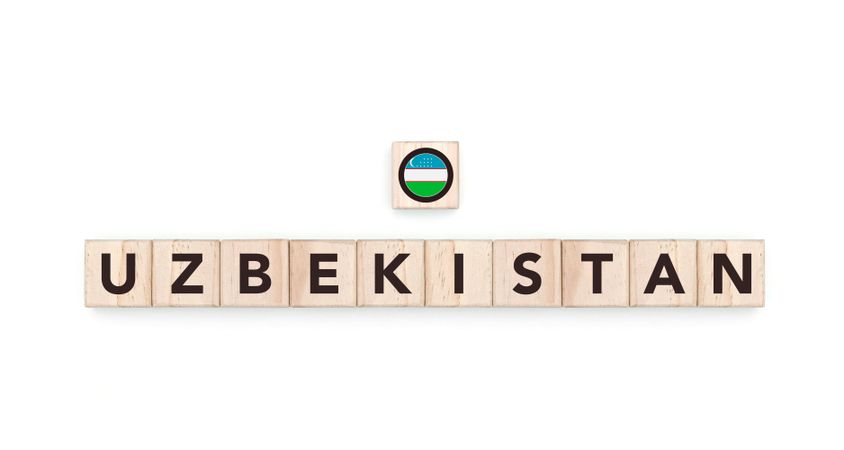 Wooden blocks bearing the name and flag of Uzbekistan. Uzbek and Asian Culture, national identity, travel, and geography in a copy space design.