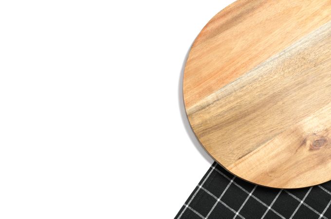 Cutting board with kitchen towel isolated on plain background, top view