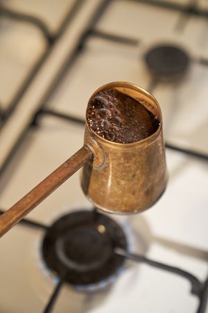 Boiling coffee in Cezve on gas stove