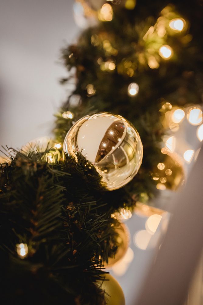 Green Christmas garland with gold bauble in close-up