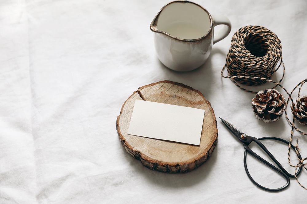 Christmas table setting of blank business card mockup on wooden board