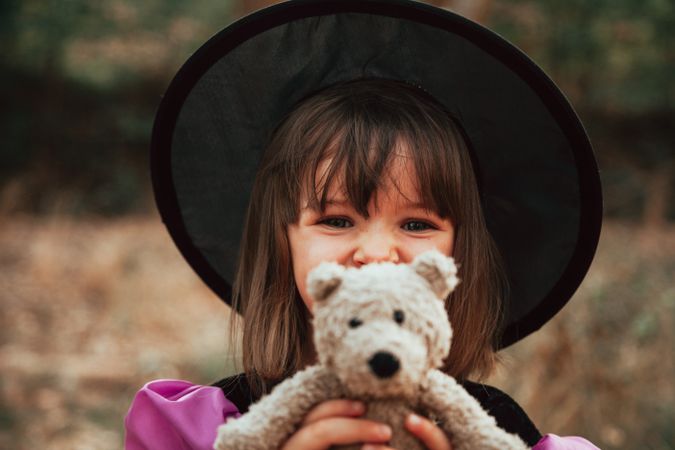 Girl with teddy bear and witch costume