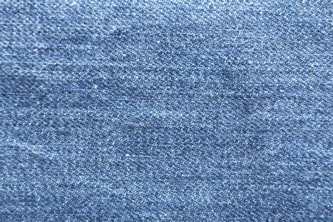 Texture of blue jeans as background, space for text