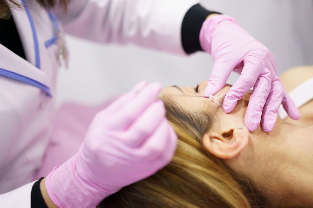 Woman having filler put into cheek